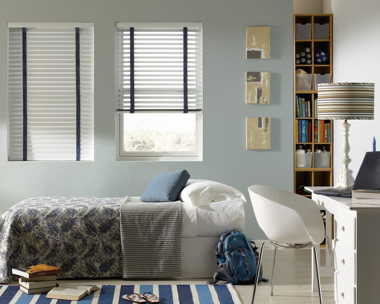 Classic Collection® Aluminum Blinds with Decorative Tape & Interior Masterpieces® Bedding white Classic Collection® Aluminum Blinds with blue Decorative Tape behind a bed with Interior Masterpieces® bedding in blue and grays