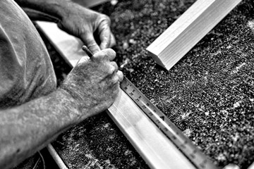 Working hands black and white photo of working hands measuring and marking