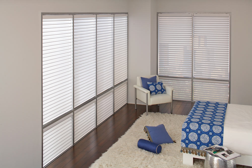 several large white Tenera® Sheer Shades & blue and white Interior Masterpieces® Custom Pillows and Bedding
